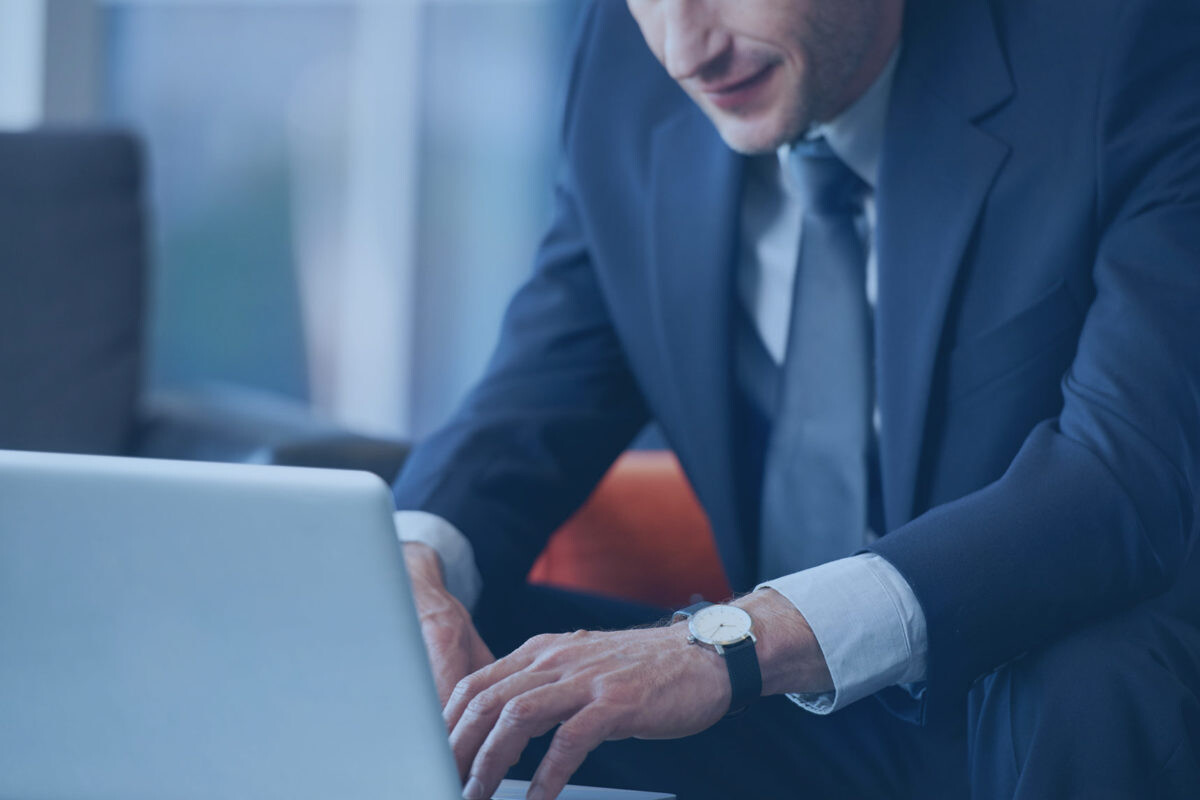 man in suit typing on a computer