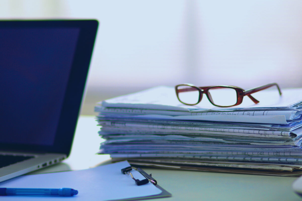 eye glasses sitting on top of stacks of paper